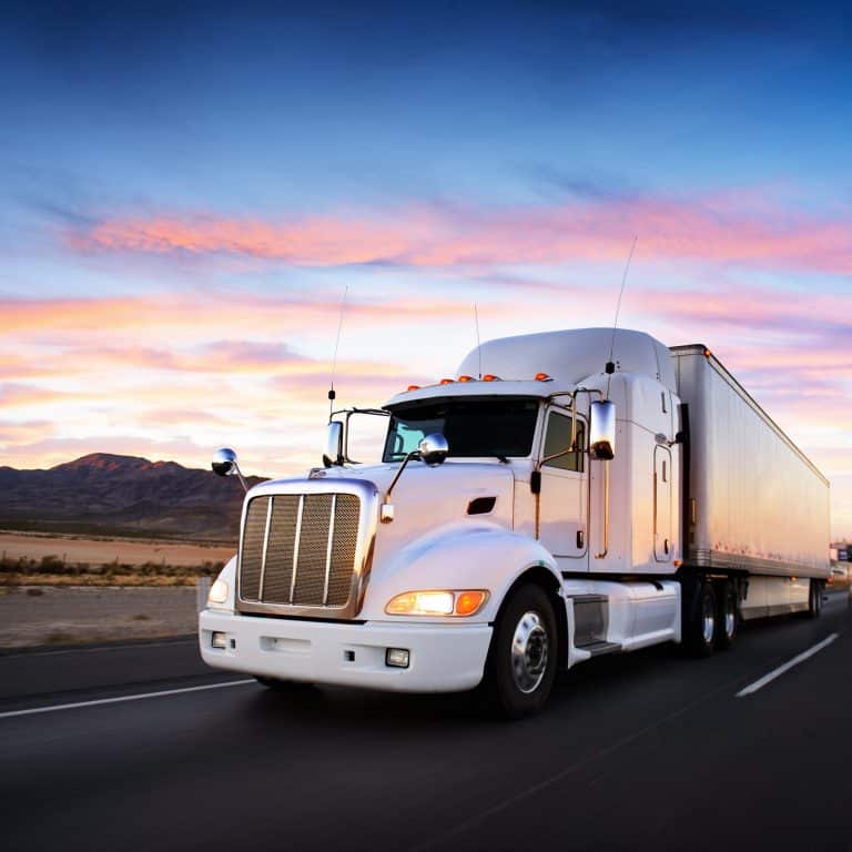 Truck on highway at sunset