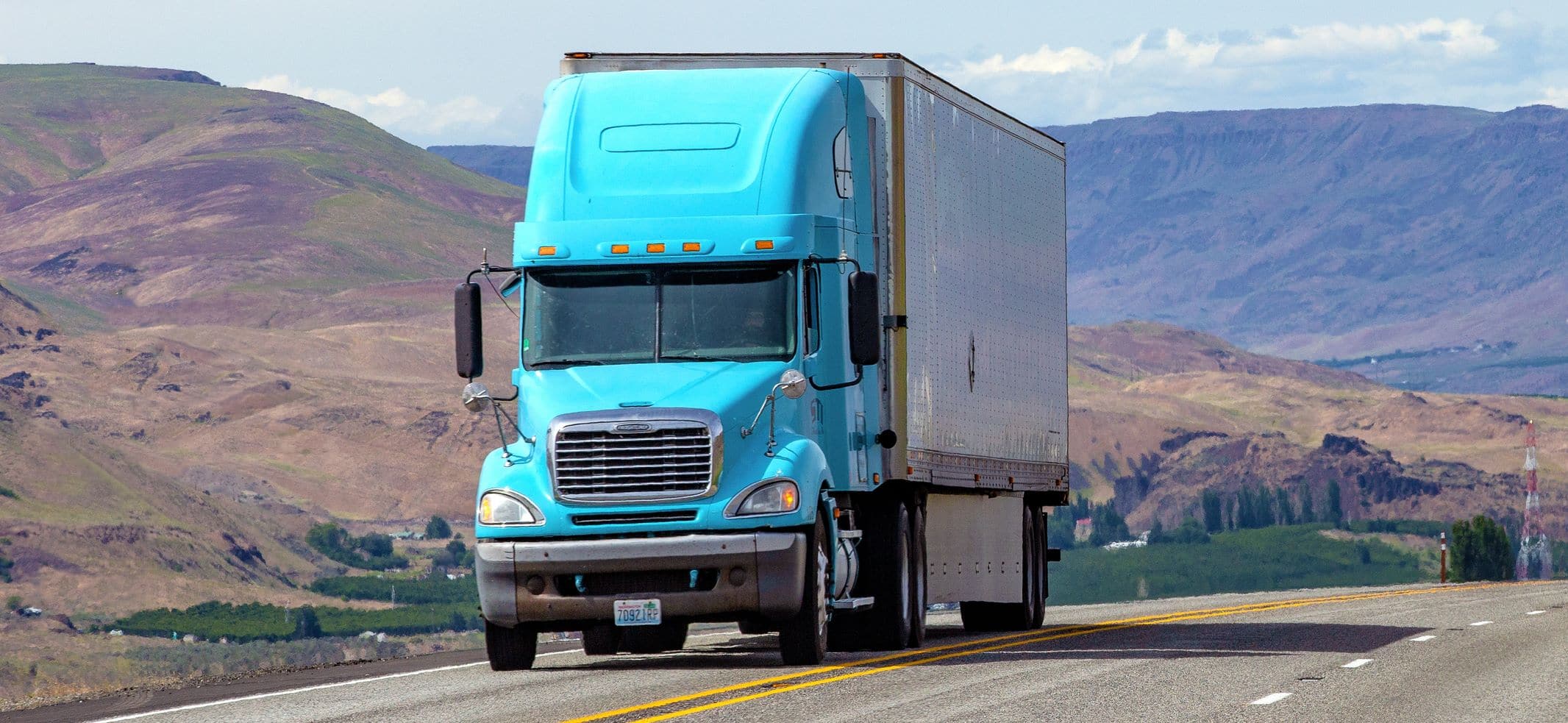 Semi truck with trailer driving on highway