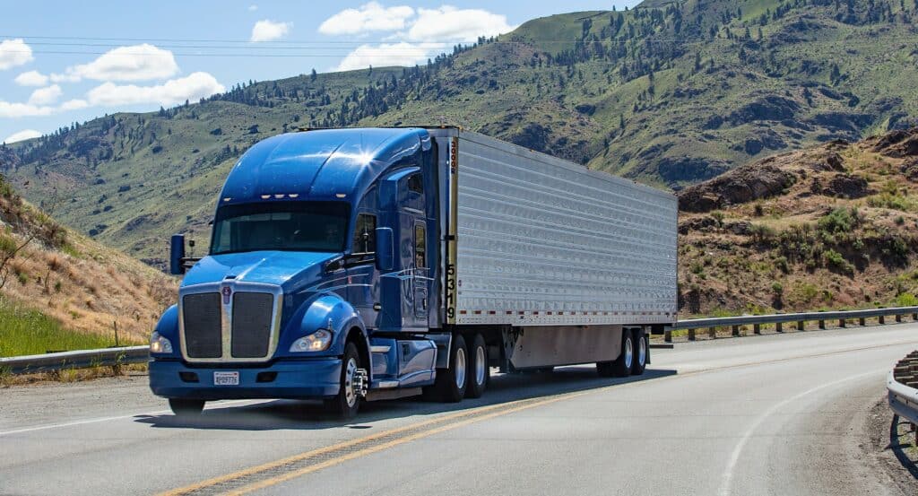 Semi truck with trailer driving on highway