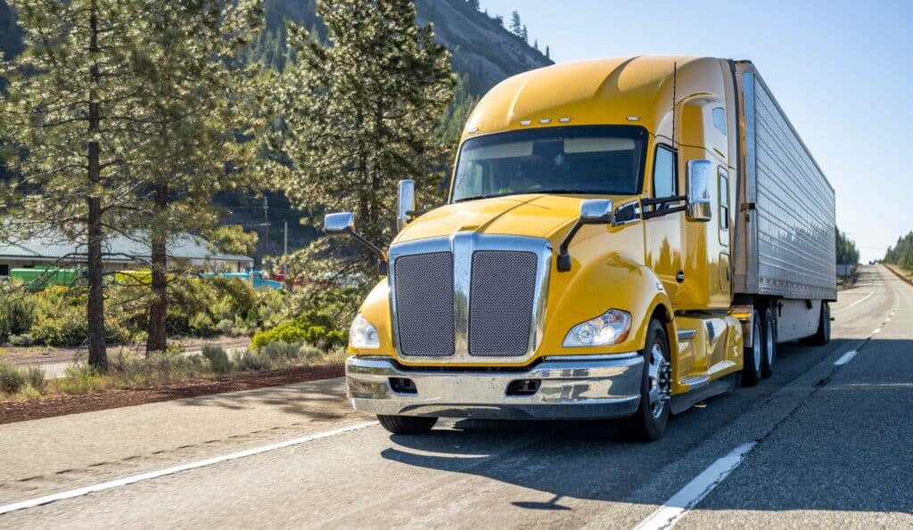 Classic long haul big rig yellow semi truck