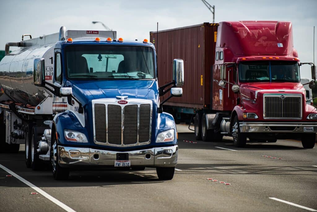 Two U.S. trucks moving along the highway.