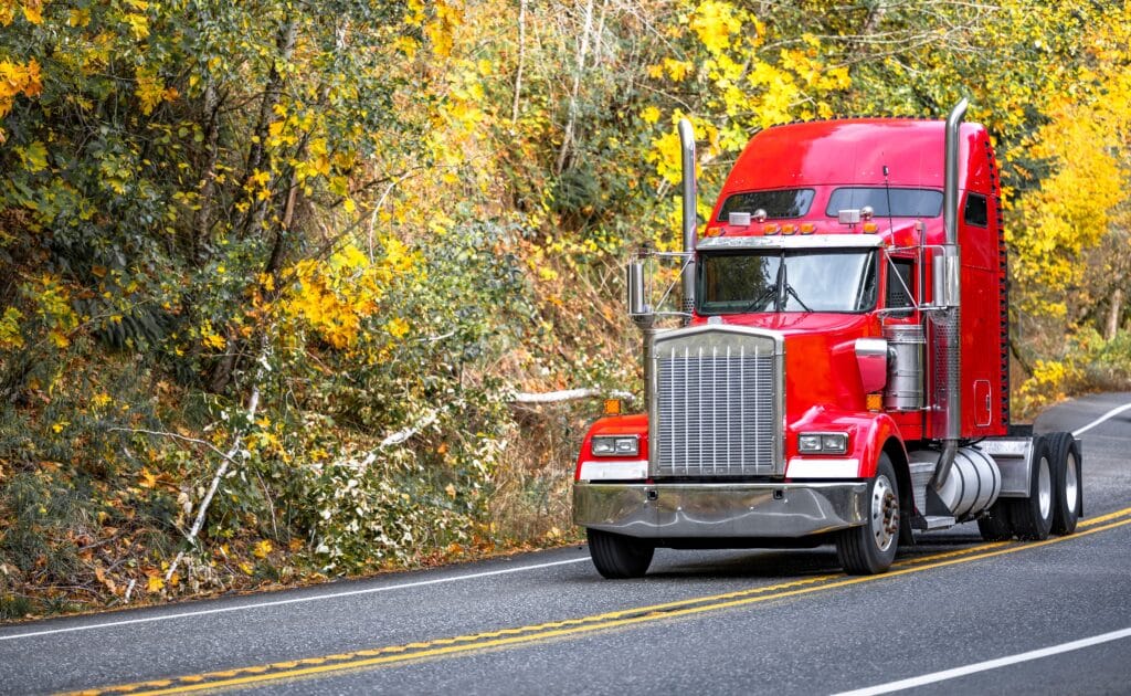red semi truck on a spring road