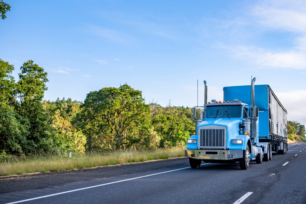 Blue big rig long haul day cab semi truck
