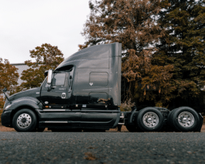 Black semi cab against trees