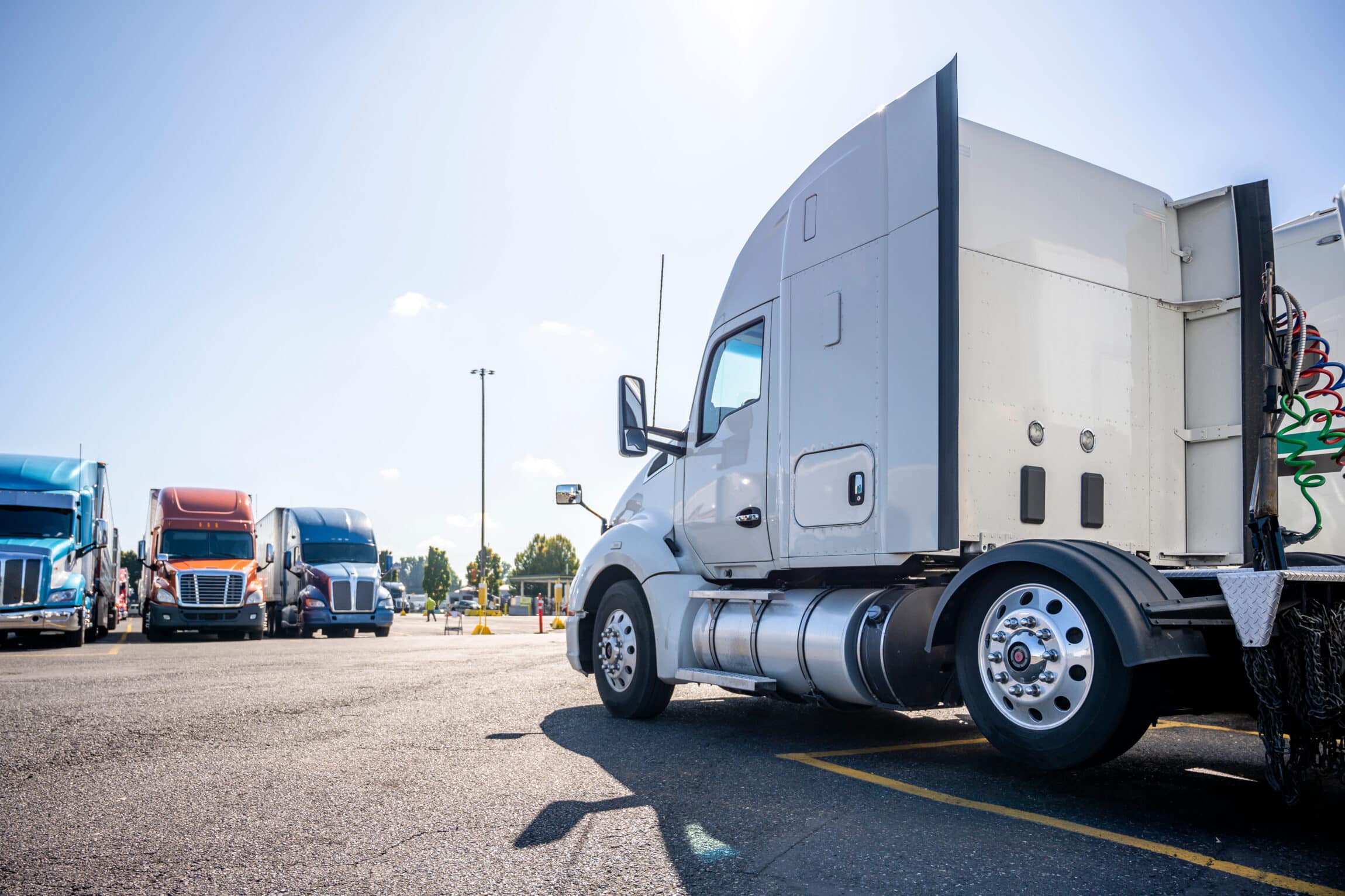 Long haul big rig white semi truck tractor stand on truck stop parking