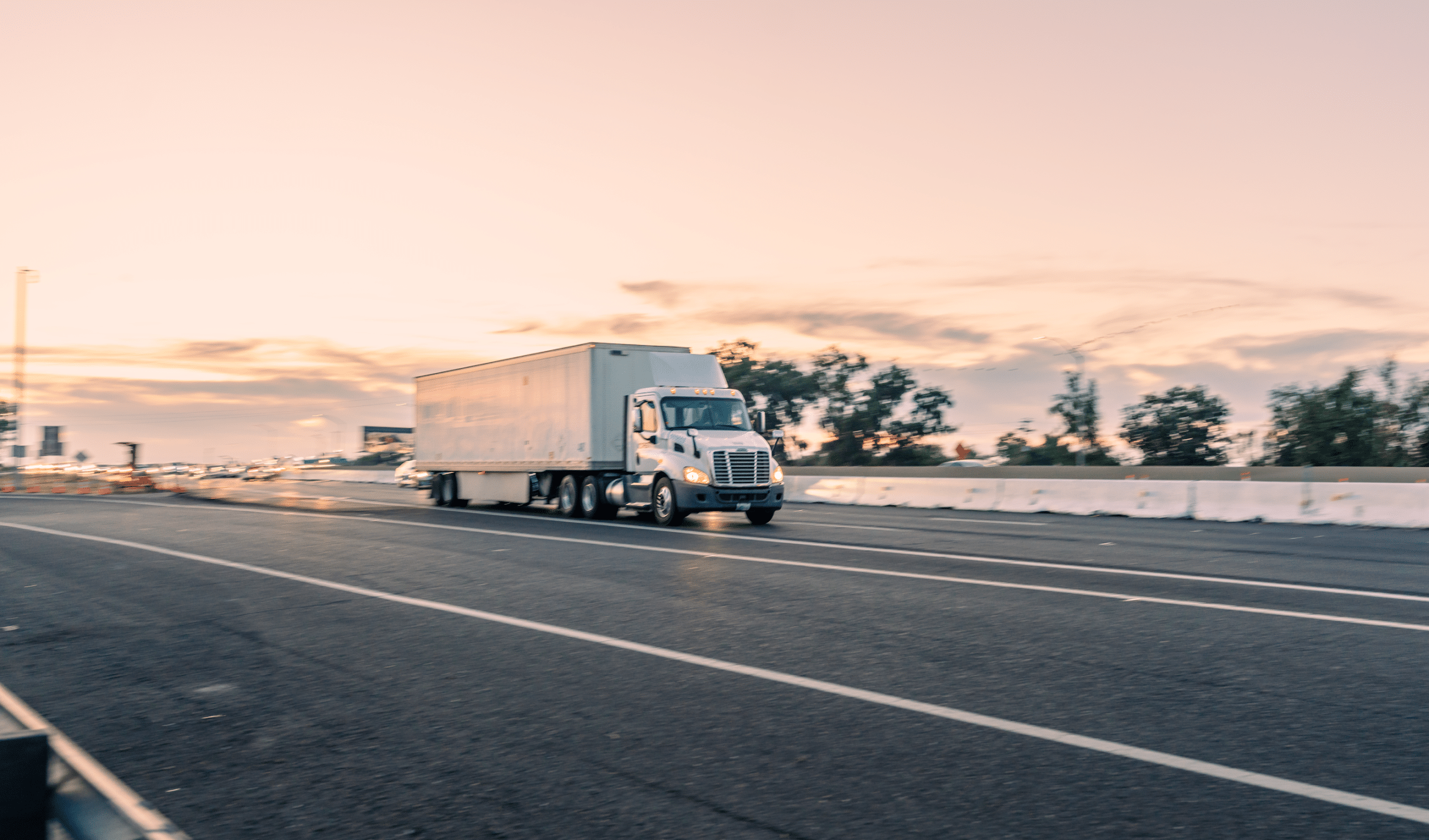 White big rig on road against pink sky