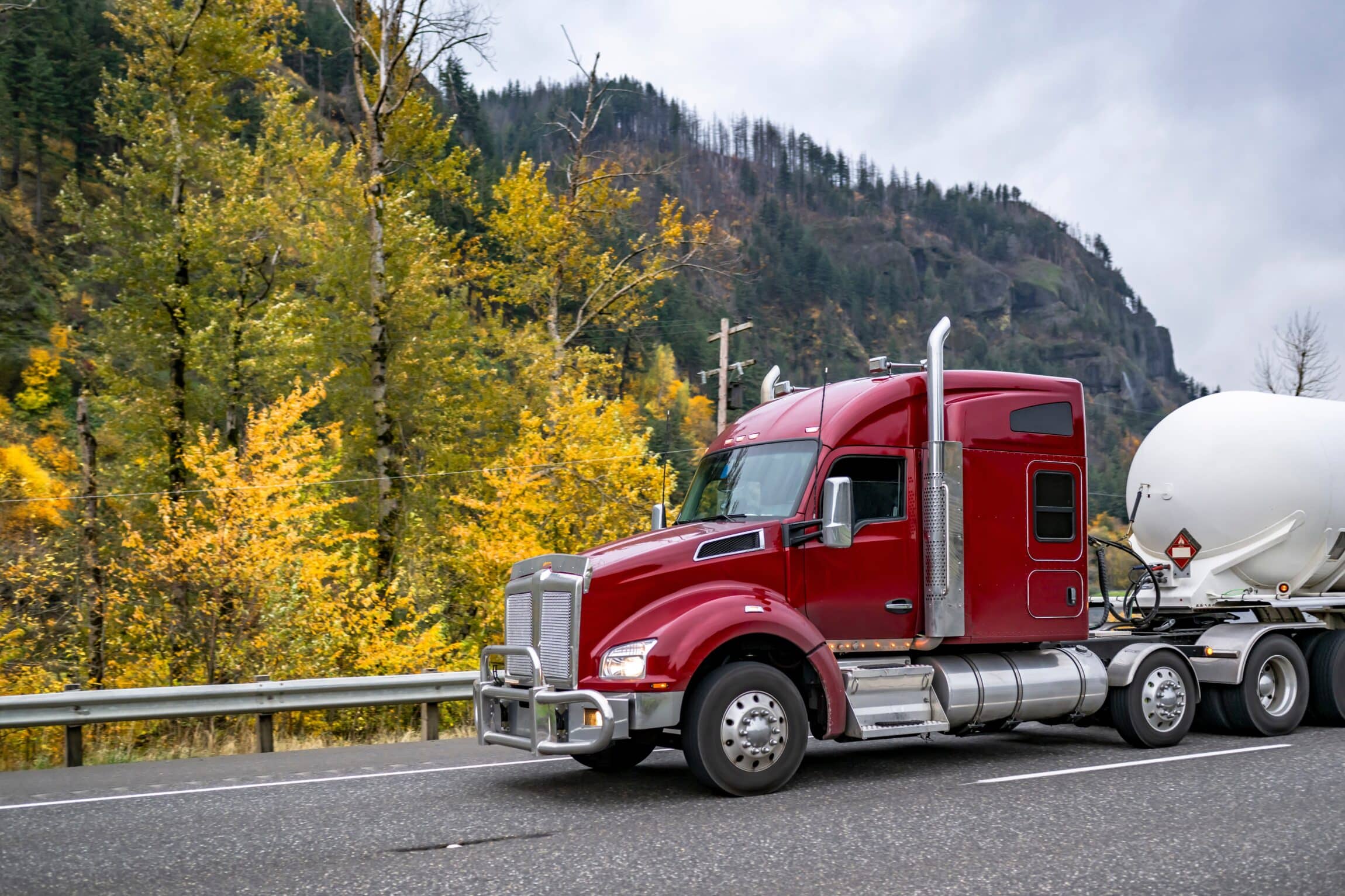burgundy big rig semi truck tractor transporting flammable chemicals
