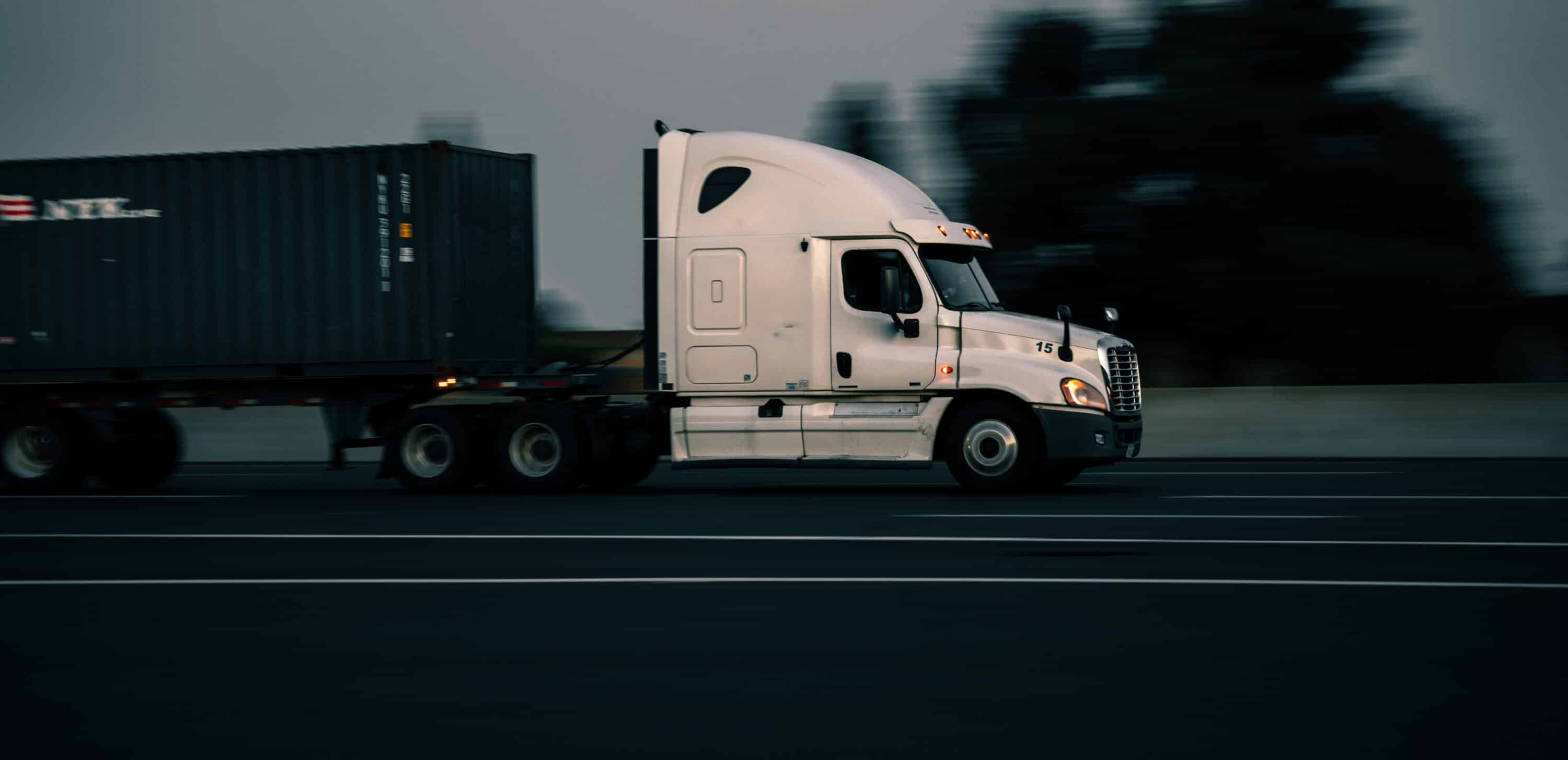 white bonnet semi truck on the road