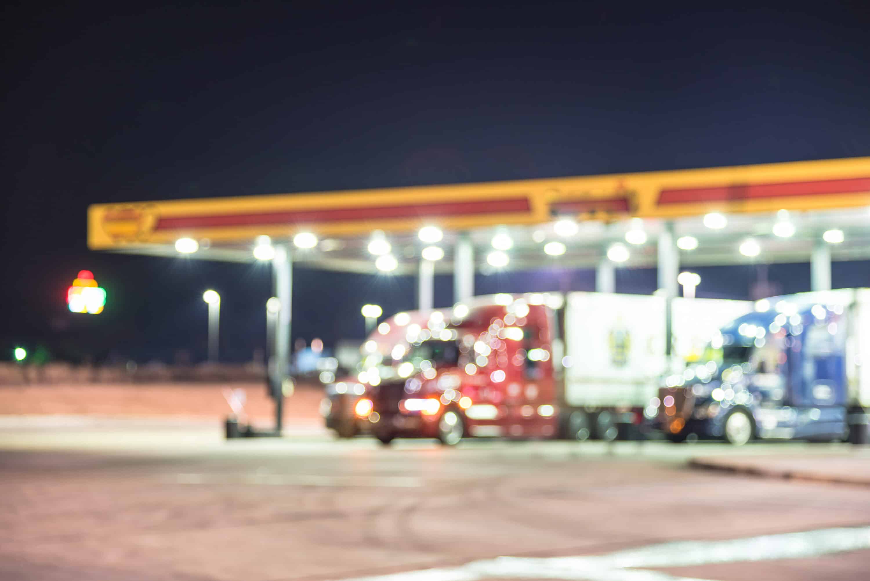 blurred photo of trucks in the gas station