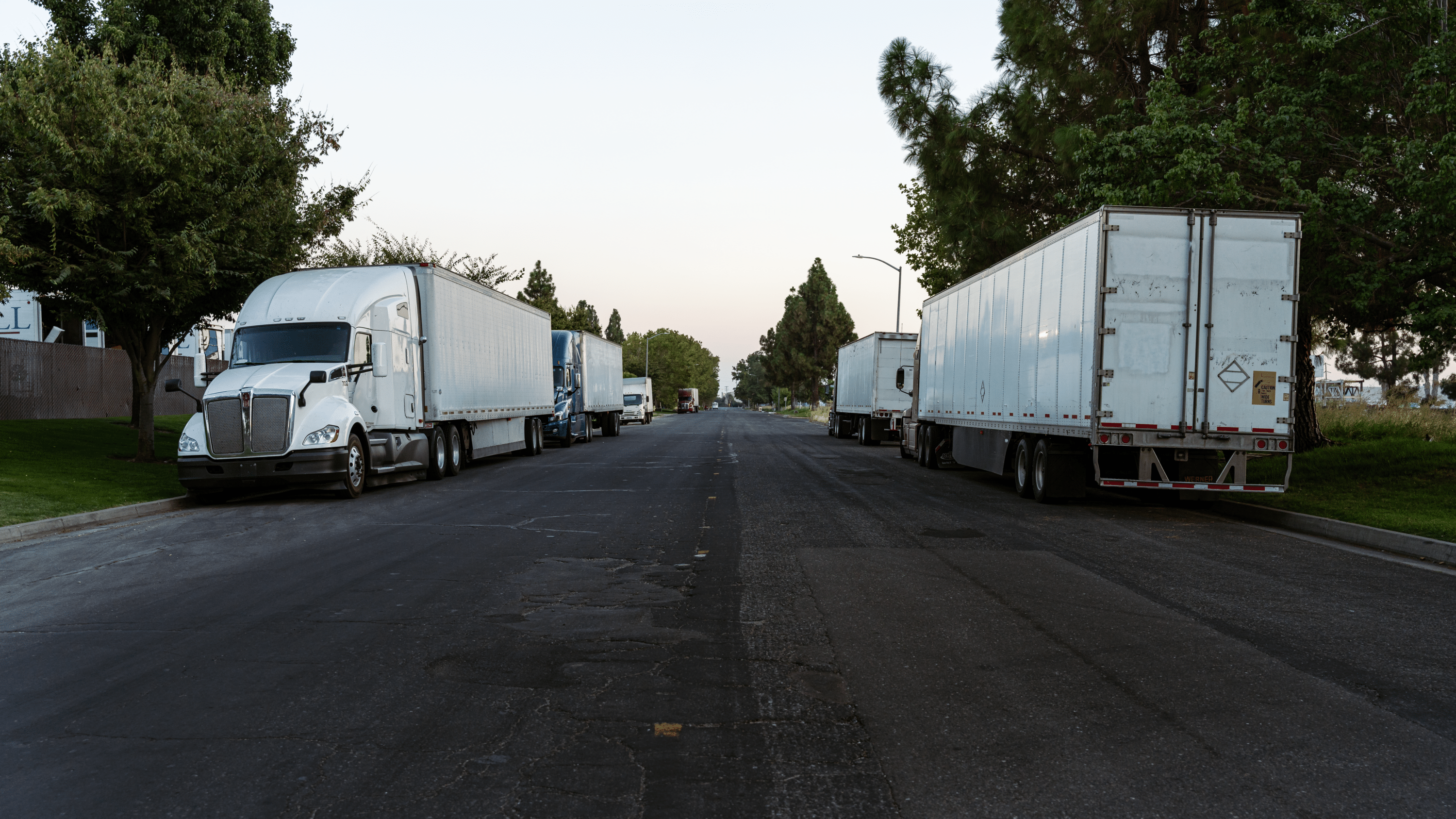 fleet of trucks are parked on the both sides of the road