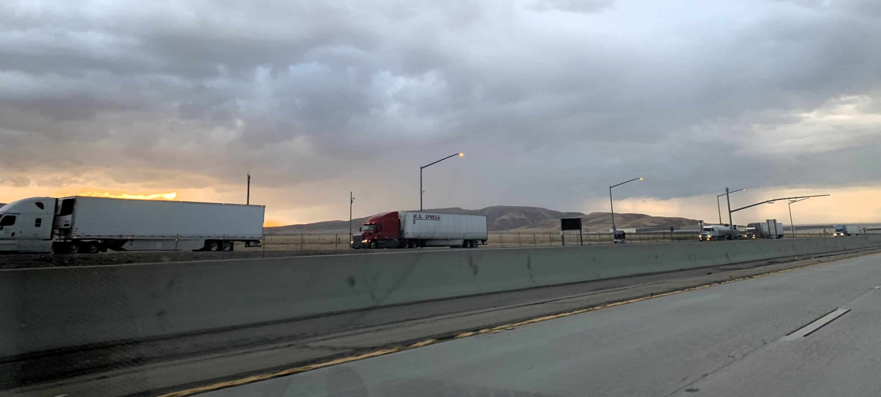 Semi trucks on the highway in the sunset