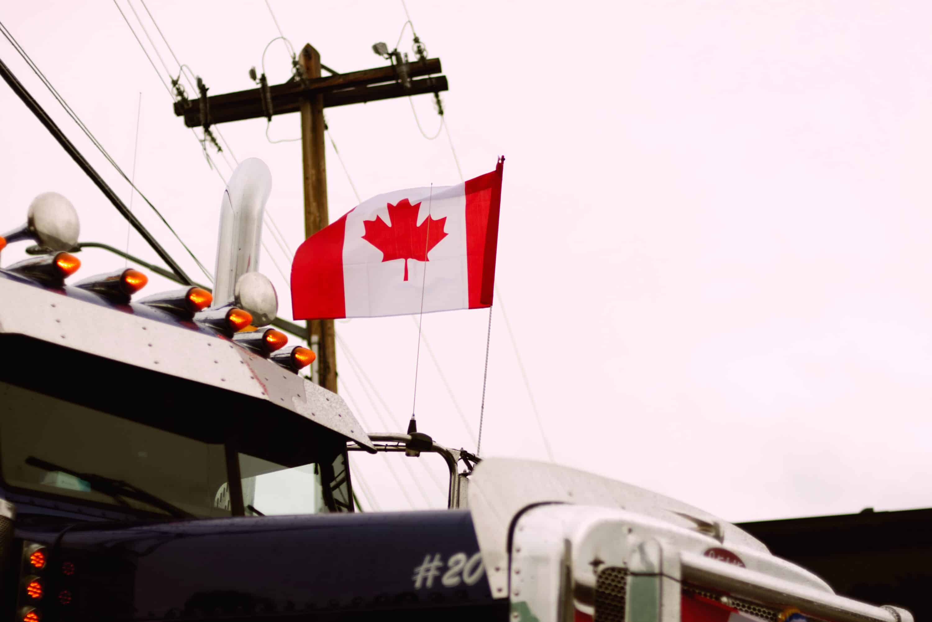 Canadian flag displayed above a parked commercial truck